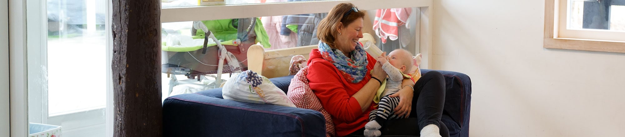 Pedagogisch medewerker Stella geeft een baby de fles